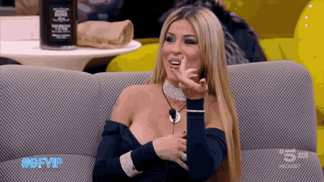 a woman sitting on a couch with the hashtag #gfvip on the screen