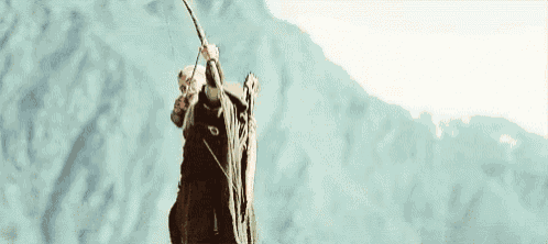a man in a green robe is holding a bow and arrow .