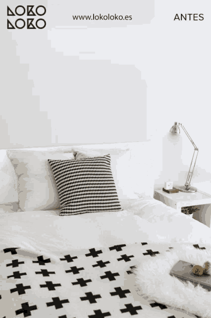 a bed with a wooden headboard and black and white pillows