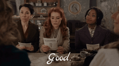 a group of women are sitting around a table and the word good is written on the table