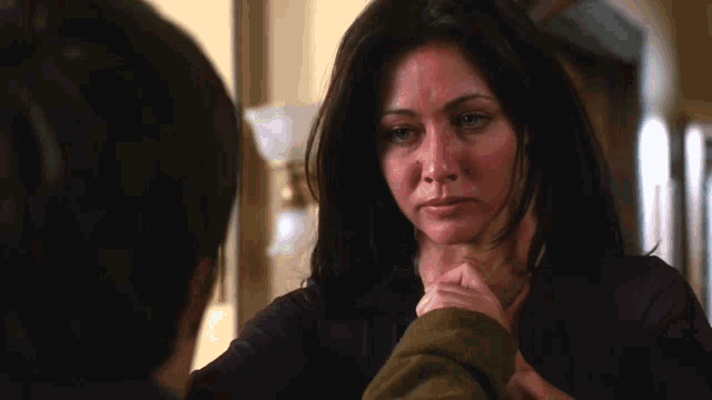 a woman in a purple sweater holds a man 's hand