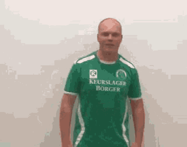 a bald man is wearing a green shirt that says keurslager borger .