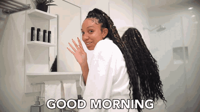 a woman in a bathrobe says good morning in the bathroom