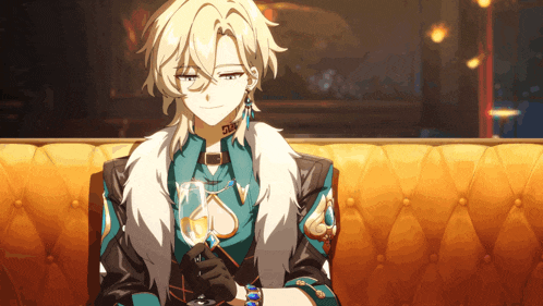 a man sitting on a couch with a glass of wine in his hand
