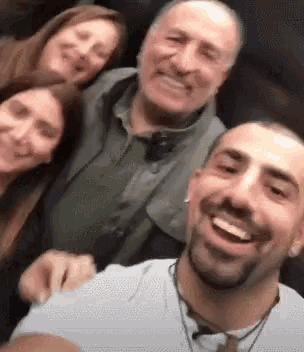 a group of people are posing for a selfie together and smiling .