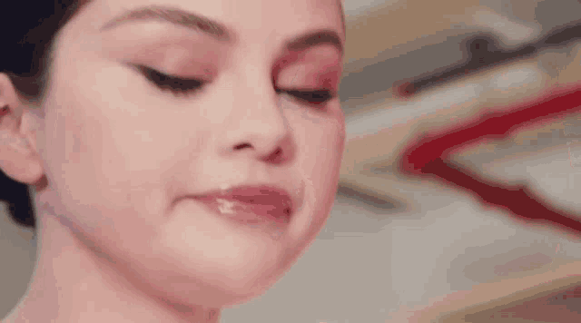 a close up of a woman 's face with her tongue out and a slight smile on her face .