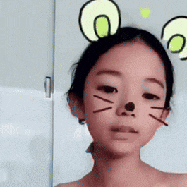 a young girl wearing a cat mask with ears on her head .