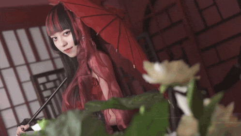 a girl with red hair is holding a red umbrella