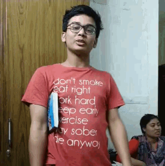 a young man wearing a red shirt that says do n't smoke eat right work hard keep early
