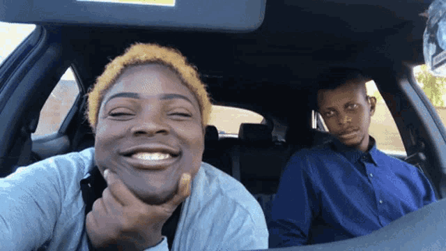 a man and a woman are sitting in a car and the woman is smiling for the camera