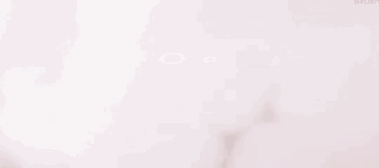 a shadow of a person standing in front of a pink light .