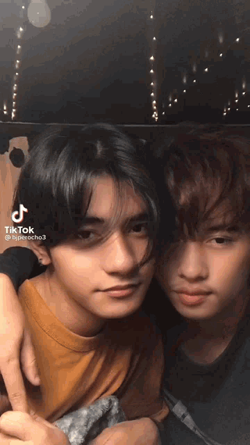 two young men are posing for a picture with tiktok written on the bottom right corner
