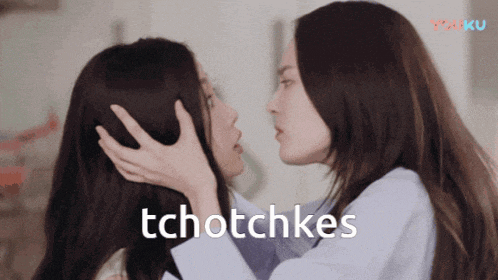 two women are kissing with the words tchotchkes written below them
