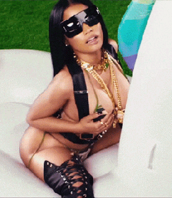 a woman wearing sunglasses and a bikini is laying on a raft