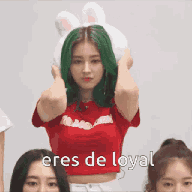 a girl with green hair is wearing a bunny hat and the words eres de loyal are below her