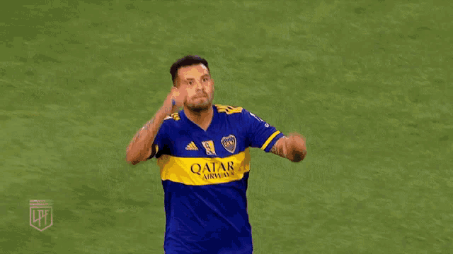two soccer players in blue and yellow jerseys are hugging each other on a field .