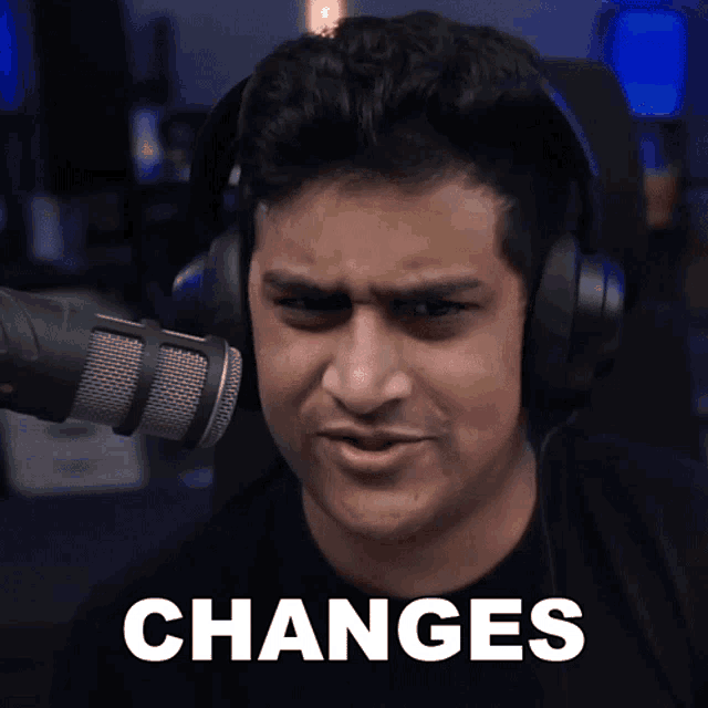 a man wearing headphones stands in front of a microphone with the word changes written in white