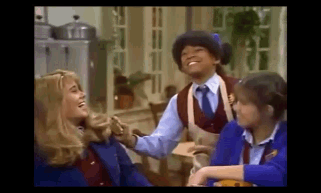 a group of people are laughing together in a kitchen .