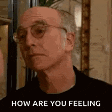 a close up of a man wearing glasses and a black shirt with the words `` how are you feeling '' .