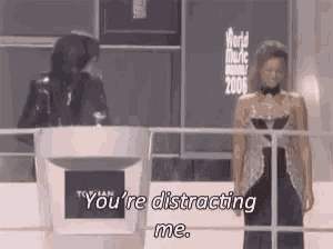 a man is standing at a podium talking to a woman .