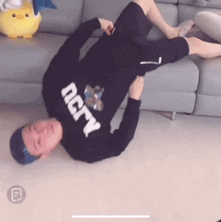 a man wearing a black sweater that says ncrv is laying on the floor