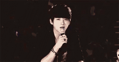 a young man is holding a microphone in his hand and crying .