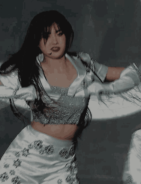 a woman wearing a crop top and white gloves
