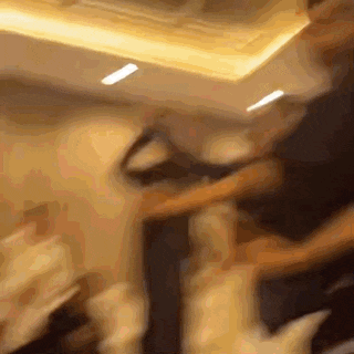 a blurry picture of a man standing in a room with a ceiling light .