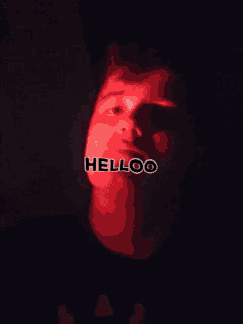 a man 's face is lit up with the word helloo on it
