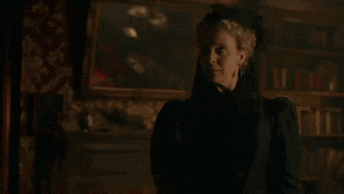 a woman in a black dress with the words get out behind her