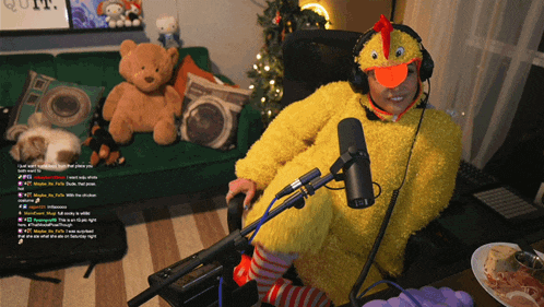 a person in a yellow chicken costume is sitting in front of a microphone