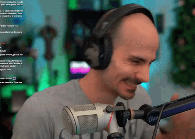 a man wearing headphones stands in front of a microphone that says blue on it