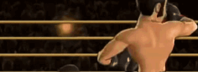 a man without a shirt is boxing in a ring .