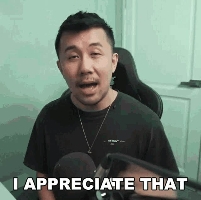 a man sitting in front of a microphone with the words i appreciate that above him