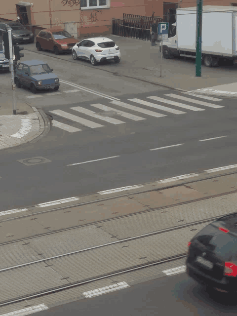 a white truck is parked on the side of the road next to a blue car