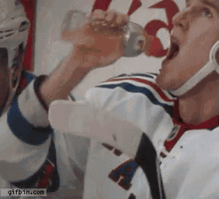 a hockey player is drinking from a bottle with the letter a on his jersey