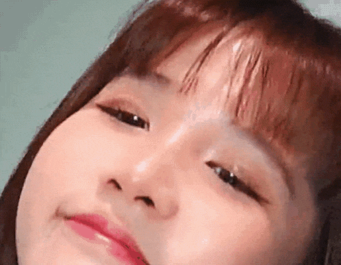 a close up of a woman 's face with her eyes closed and a smile on her face .