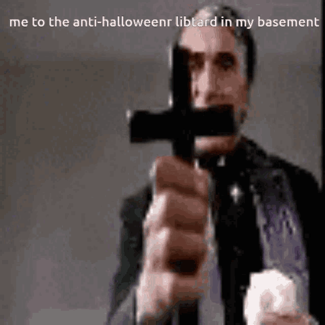 a priest is holding a cross in his hand and pointing at the camera .