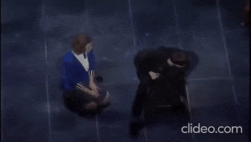 a man and a woman are sitting next to each other on the floor .