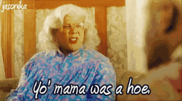 a woman in a wig is sitting on a couch and says yo mama was a hoe