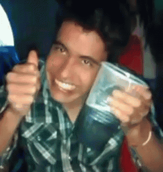 a man in a plaid shirt is holding a plastic cup and giving a thumbs up sign