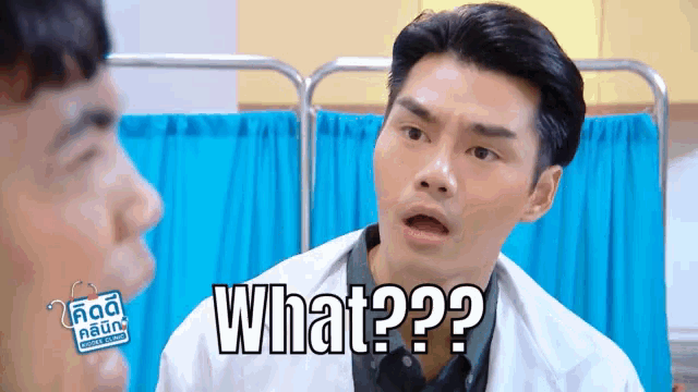 a man in a lab coat is talking to another man and says what