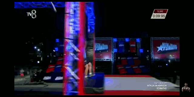a man in a blue shirt is jumping on a trampoline in front of a tv8 logo