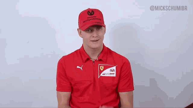 a man wearing a red shirt and a red hat that says " created by mercedes-benz "