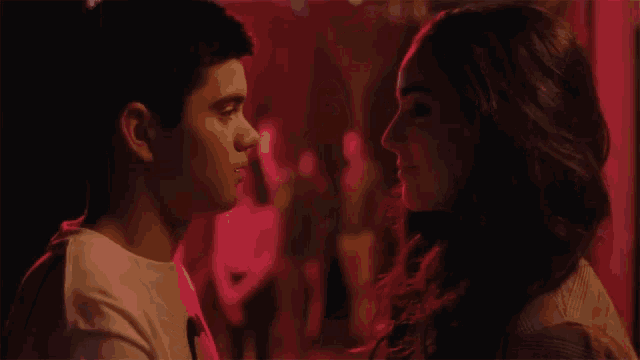 a man and a woman are kissing in the dark
