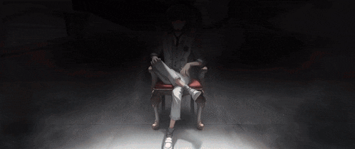 a person is sitting in a chair with their legs crossed in a dark room
