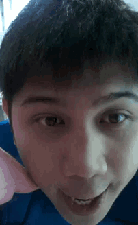 a close up of a person 's face with a pink object in the background
