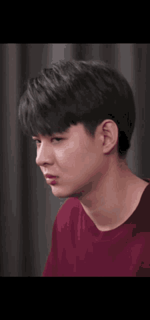 a close up of a person 's face with a red shirt on