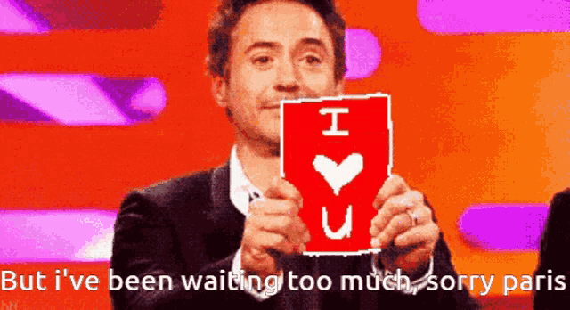 a man is holding a card that says " i love you "