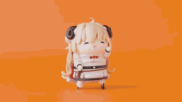 a doll with horns is standing on a orange background